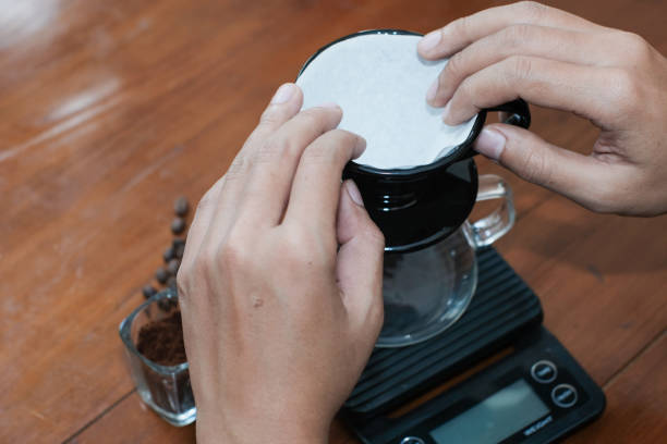 Closeup of a hand prepare filter paper on dripper to brew coffee v60