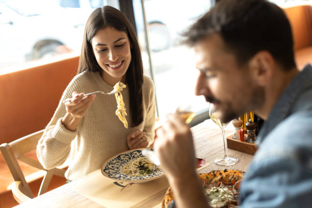 istock Loving couple eating spaghetti at the restaurant 2180095709