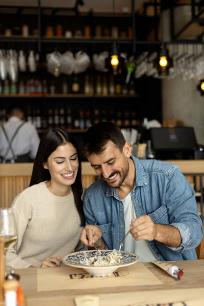 istock Loving couple eating spaghetti at the restaurant 2180095830