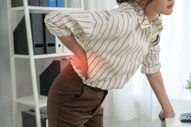 istock woman holding her lower back while and suffer from unbearable pain health and problems, chronic back pain, backache in office syndrome, scoliosis, herniated disc, muscle inflammation 2180105794