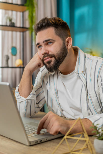 istock Freelancer man prepares startup project for presentation finds idea using laptop at home office 2180109851