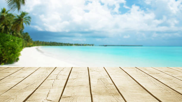 istock Empty wooden table top with beautiful tropical paradise beach background 2180111278