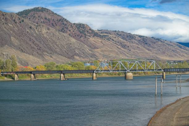 istock Scenic River View with Bridge and Mountains 2180112198