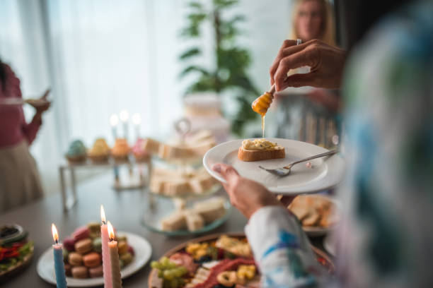 A guest lovingly adds a golden stream of honey to a dessert, symbolizing the sweet beginnings at a baby shower celebration.
