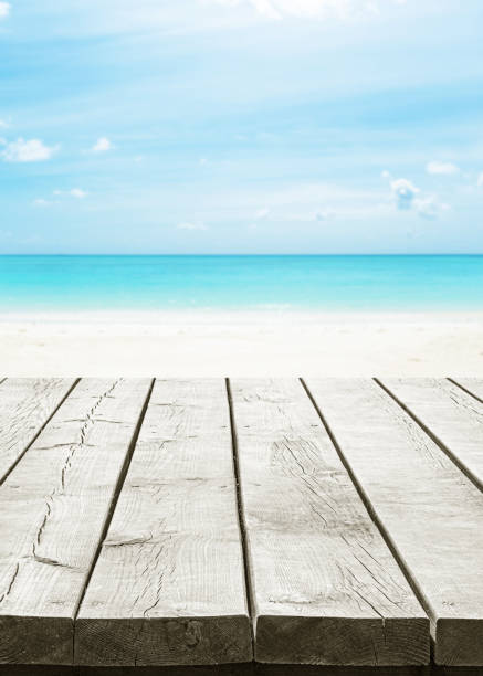 istock Empty wooden table top with turquoise sea and sunny blue sky background 2180113475