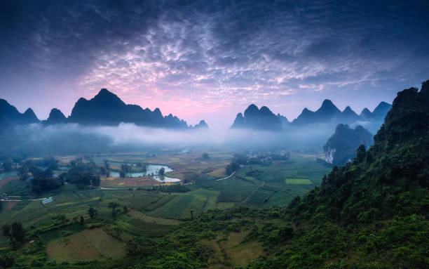 istock Dramatic sunrise over mountain range with foggy and river flows through in Phong Nam Valley 2180122934