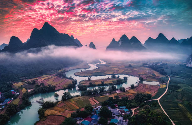 istock Dramatic sunrise over mountain range with foggy on rural village and river flows through in Phong Nam Valley 2180122940