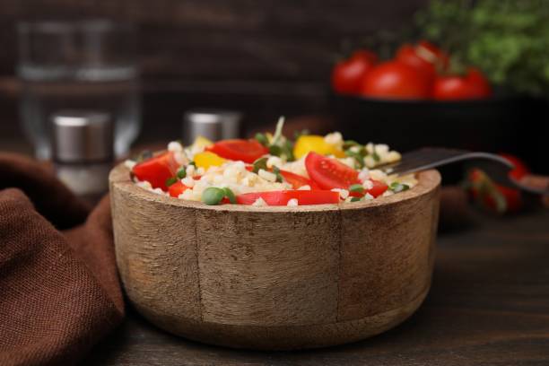 istock Cooked bulgur with vegetables in bowl on wooden table, closeup 2180128614