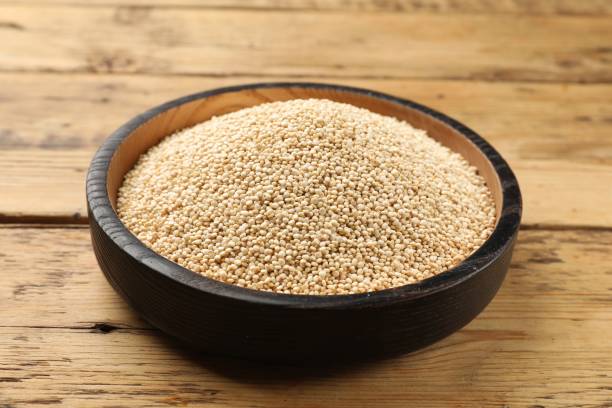 istock Dry quinoa seeds in bowl on wooden table, closeup 2180128621