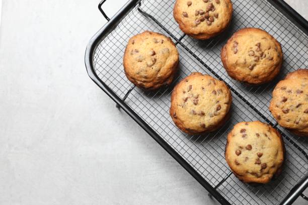 istock Cooling rack with delicious chocolate chip cookies on light gray table, top view. Space for text 2180130010
