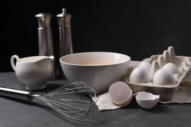 istock Metal whisk and dough ingredients on dark grey table 2180130181