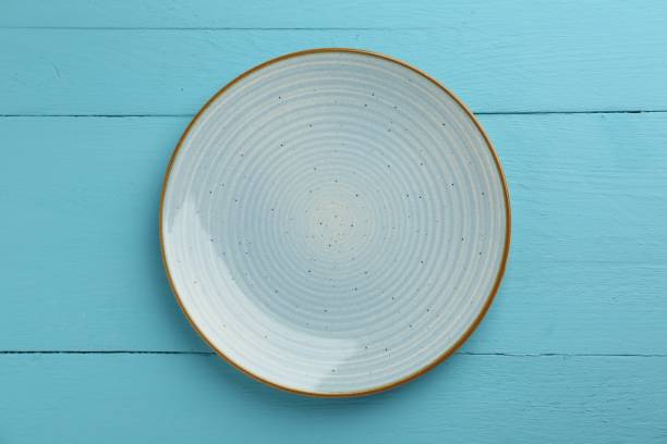 istock Beautiful ceramic plate on light blue wooden table, top view 2180130545