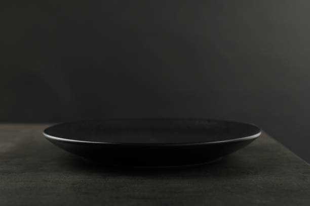 istock Beautiful ceramic plate on gray table against black background, closeup. Space for text 2180130548