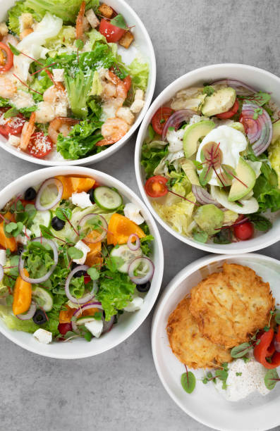 istock Three different vegetable salads and slavic draniki (potato pancakes) on gray marble background 2180133228