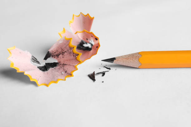 istock One sharp graphite pencil and shavings on white background, closeup 2180133375