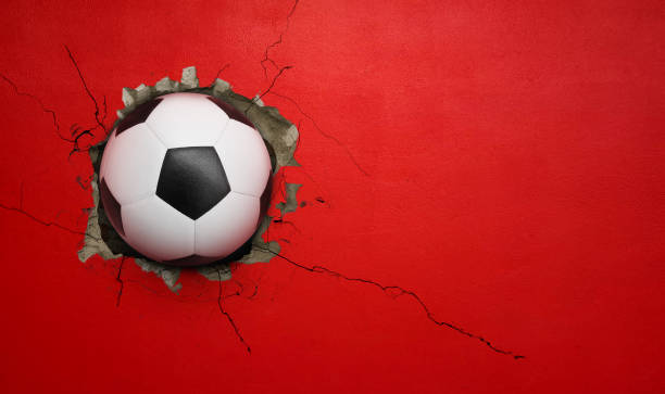 istock Soccer ball breaks through red concrete wall, concept of power, strength. 2180134312