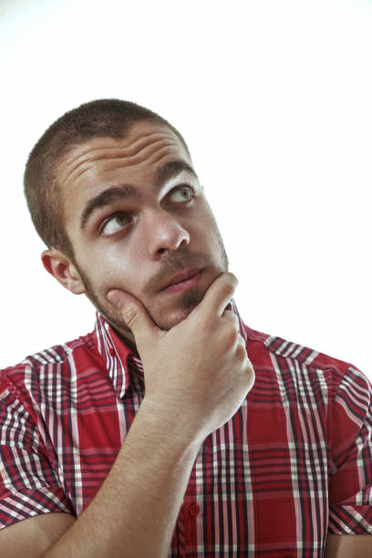 istock Young man looking up and thinking with hand on chin 2180136188