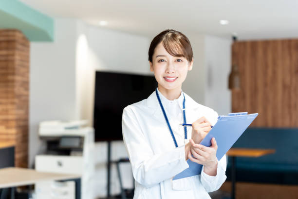 医療施設で働く白衣の女性 - クリニック ストックフォトと画像
