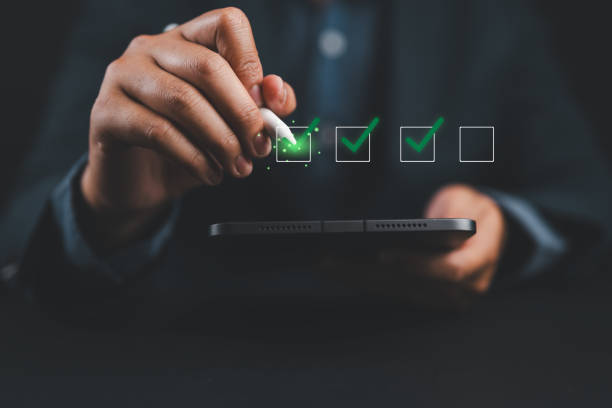 istock Businessman checking mark on checklist with a red checkmark. online checklist survey, filling out digital form checklist. take an assessment, questionnaire, evaluation, online survey, online exam. 2180142622