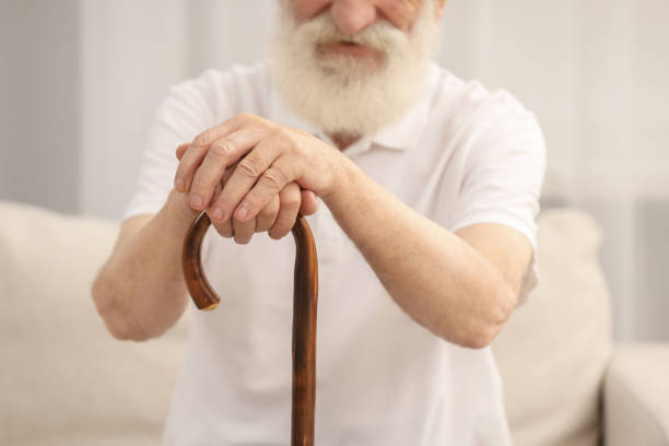 istock Senior man with walking cane on sofa indoors, closeup 2180143679