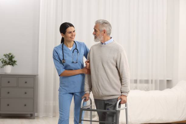 istock Smiling nurse talking with elderly patient in hospital 2180143690