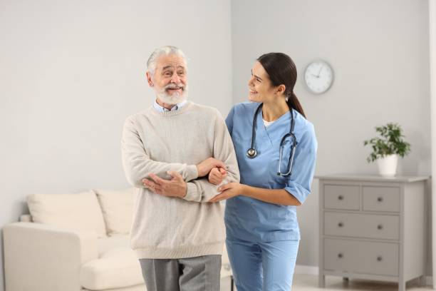 istock Smiling nurse supporting elderly patient in hospital 2180143699