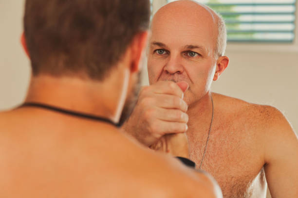 Two shirtless athletes practicing a grappling martial art, possibly brazilian jiu jitsu or mixed martial arts, are locked in a hold, showcasing the dynamics of power and control