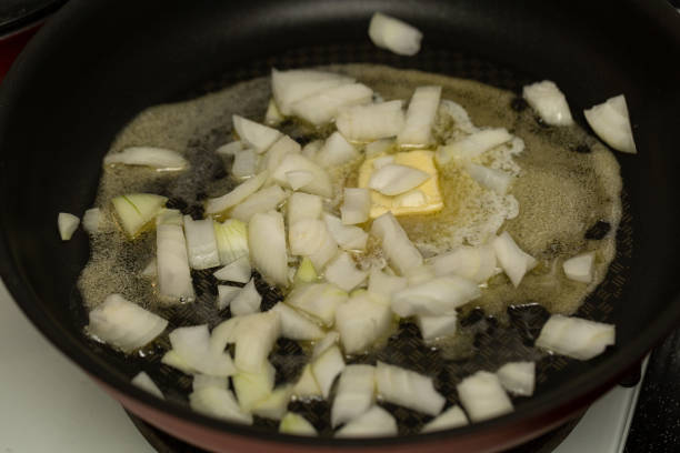 Finely chopped onions are fried in butter, close-up