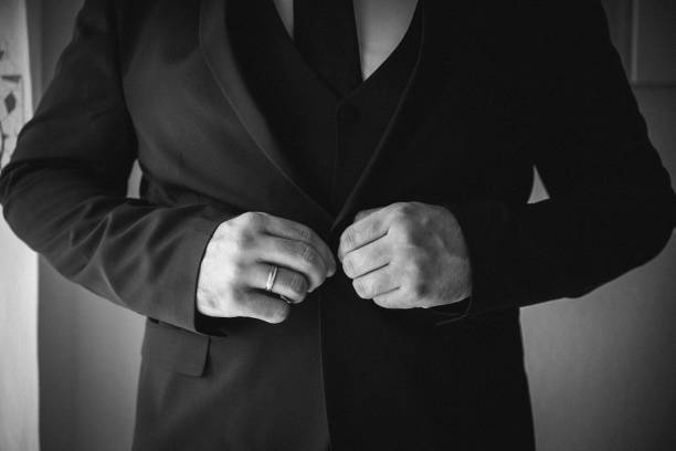 istock Man buttoning his suit jacket in black and white 2180154613