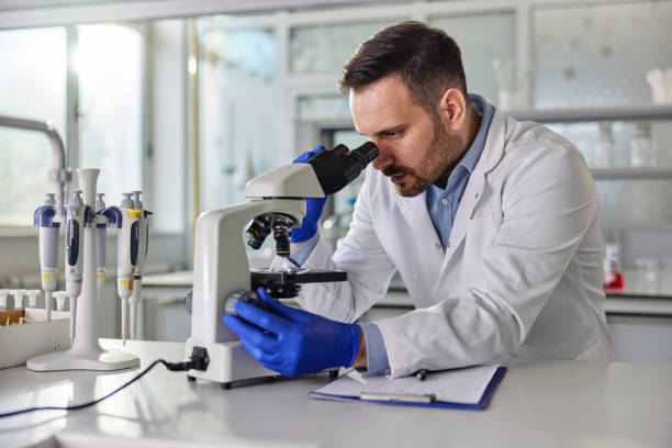 istock Young male scientist working on a microscope in laboratory. 2180157653