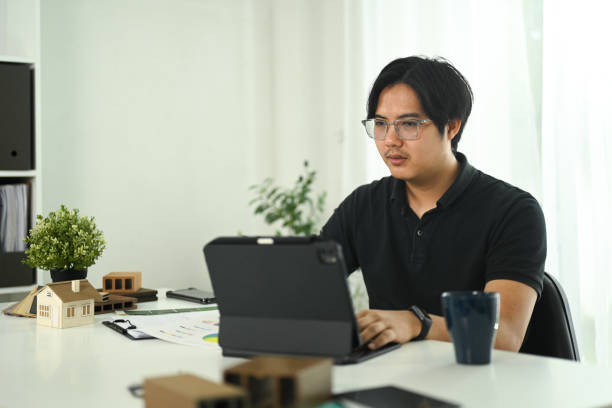 istock Interior designer reviewing project details and using digital tablet at modern office 2180157749