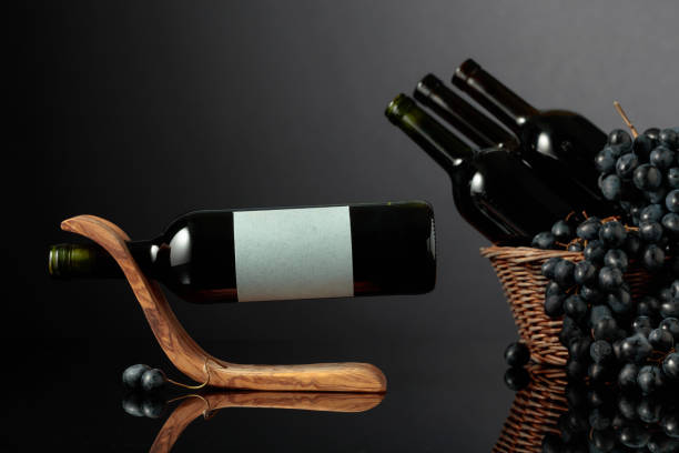 istock Red wine and blue grapes on a black reflective background. 2180157794