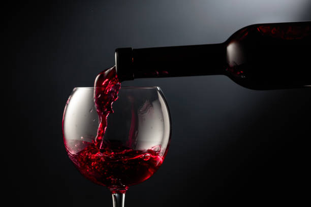 istock Pouring red wine into a wine glass. 2180157830
