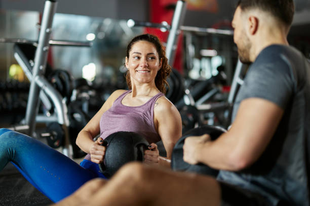 istock Happy athletic couple talking while exercising strength in a gym. 2180159007
