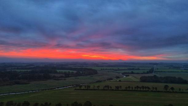 istock Sunrise over lush landscape with vibrant hues. 2180159811