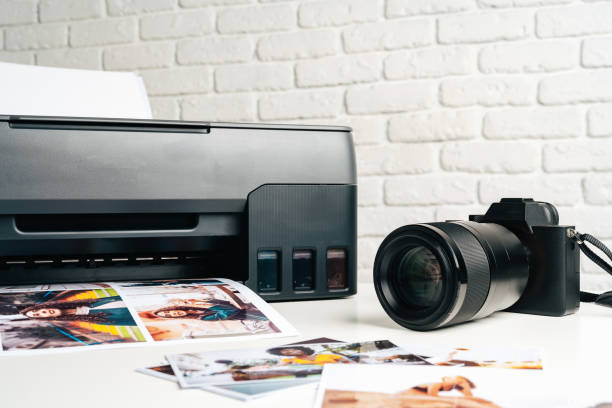 istock Printer and photo camera on table. Printing photos concept 2180160730