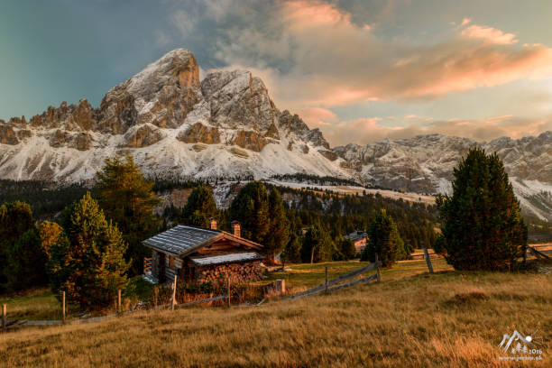 Passo Erbe under the mountain Peitlerkofel, or Sass de Putia at sunset with wood hut