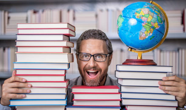 istock Man geographer with books in classroom. Knowledge and education concept. school teacher with book in classroom. teacher in classroom. Teachers Day. Tutor at classroom. future through education 2180164665