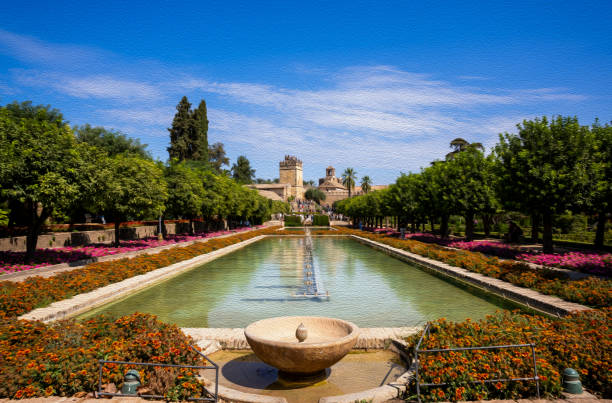 Cordoba, Spain - January 28, 2025: Row of Monumental Cypress Trees Reflection in Calm Water Fountain