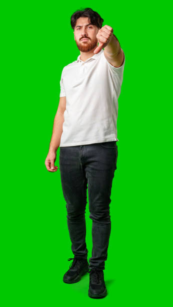 istock A man expresses disappointment with a thumbs down gesture against a bright green background 2180165459
