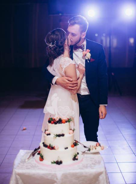 istock A bride and a groom with their wedding cake 2180166298