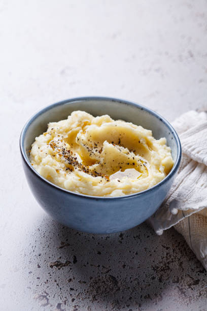 istock Mashed potatoes with butter and pepper in blue bowl. 2180167503