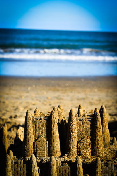 Two small sand castles on the seashore of a beach. Child's play. Fun