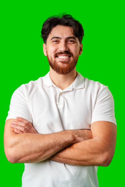 istock A smiling young man with a beard poses against a bright green background 2180172506
