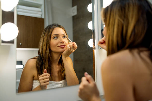 istock Woman highlighting eyebrows in bathroom mirror. 2180175089