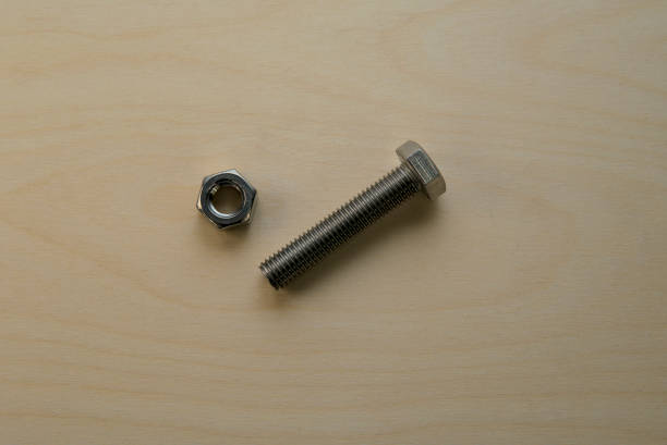 istock Stainless steel hex bolt and nut on a wooden surface diagonal set. 2180176163