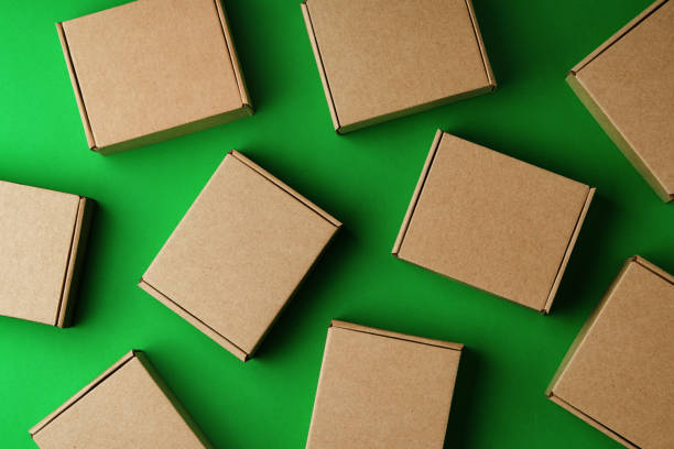 istock Brown cardboard boxes arranged on a vibrant green surface 2180179223