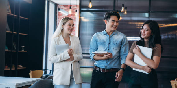 istock businesspeople discussing papers and working on laptops, indicating active discussion or presentation,with a laptop in the background. 2180186363