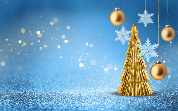 Gold Christmas tree, snowflake and bauble on shiny glitter blue background with bokeh light. Festive winter holiday decoration and ornament.