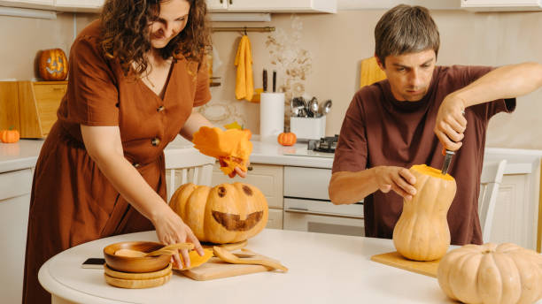 istock Middle-aged married couple carves a pumpkin for Halloween 2180197501